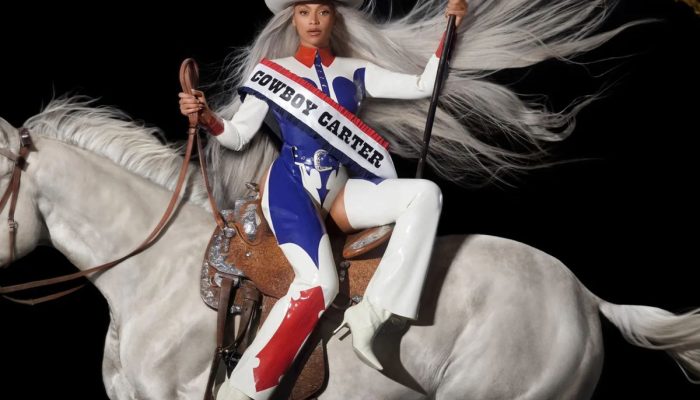 Beyoncé - Imagem de uma mulher montada em um cavalo, vestindo um traje estiloso e segurando uma bandeira, simbolizando o tema Cowboy Carter.